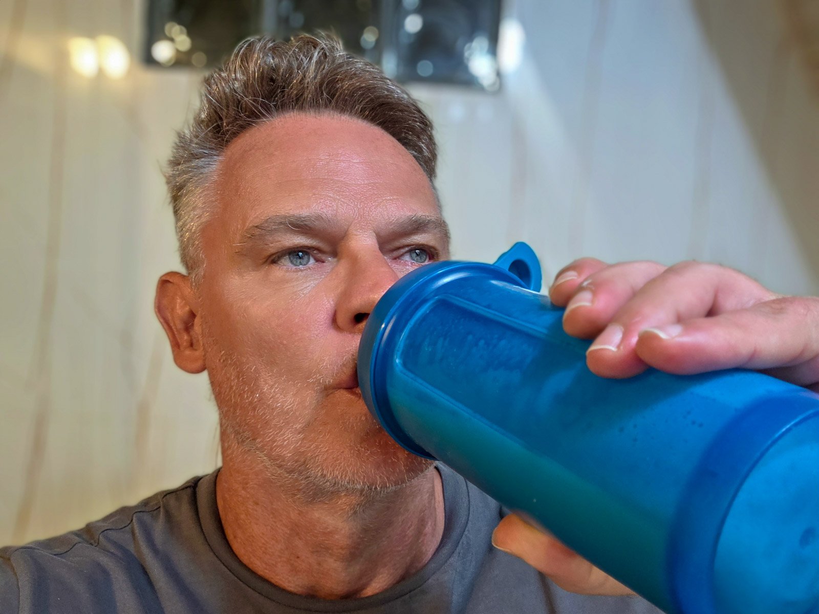 Martin drinking a protein shake after a workout as part of his daily protein intake routine.
